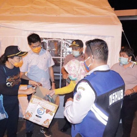 Ketua TP-PKK Kota Bitung, Khouni Lomban-Rawung, memberikan APD sederhana kepada petugas Dinas Perhubungan yang bertugas di perbatasan Bitung-Minut.